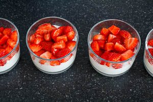 Quark-Konfekt-Masse und Erdbeeren in die Gl&auml;ser schichten