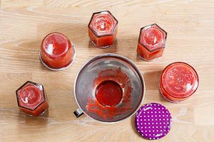 Erdbeermarmelade in sterilisierte Gläser füllen