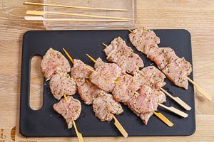 Souvlaki-Fleischscheiben auf eingeweichte Holzspie&szlig;e aufspie&szlig;en