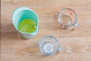 Geschälten Knoblauchzehen, Milch und Öl in ein Mixgefäß geben.