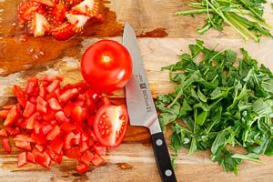 Tomaten und Rucola f&uuml;r den Nudelsalat klein schneiden