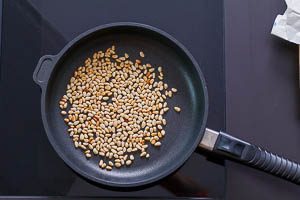 In der Pfanne goldbraun anger&ouml;stete Pinienkerne f&uuml;r Spaghettisalat