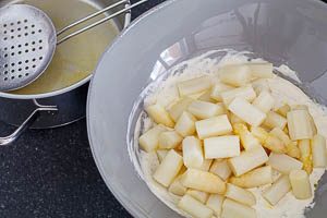 Spargel und Dressing für Spargelsalat miteinander mischen