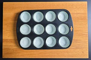 Muffinblech mit Papierförmchen füllen