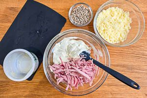Füllung mit Frischkäse, Kochschinken und Bergkäse für den gebackenen Kürbis und separat Sonnenblumenkerne vorbereiten