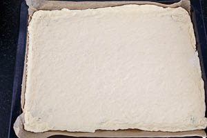 Den Zwiebelkuchen Boden aufs Backblech