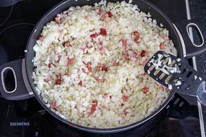 Zwiebeln und Speck in der Pfanne dünsten
