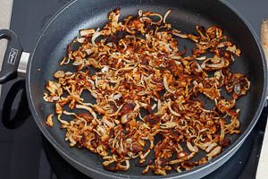 R&ouml;stzwiebeln als Topping f&uuml;r die K&auml;sesp&auml;tzle in der Pfanne anbraten