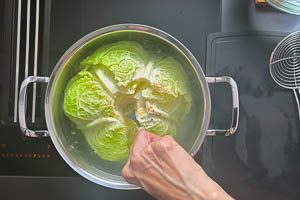 Ganzen Wirsing in einem Topf tauchen, die Bl&auml;tter l&ouml;sen sich dann selbstst&auml;ndig.