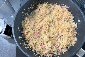 Gem&uuml;sebr&uuml;he hinzugeben und Sauerkraut k&ouml;cheln lassen