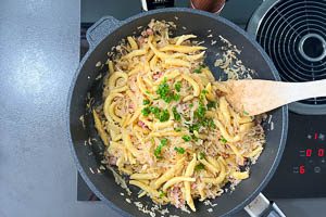 Gebratene Schupfnudeln zugeben und mit Schnittlauchr&ouml;llchen garnieren.