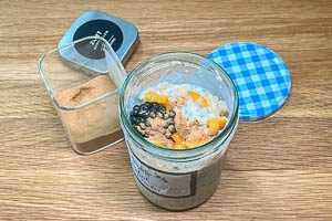 Weitere Zutaten wie Obstst&uuml;ckchen und Zimt zu den Oats geben