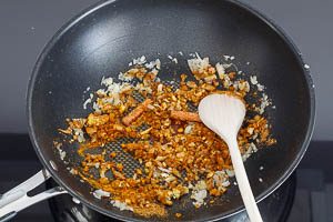 Ingwer, Knoblauch und Gewürze in der Pfanne andünsten