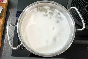 Topf mit Wasser und Reis zum Kochen bringen