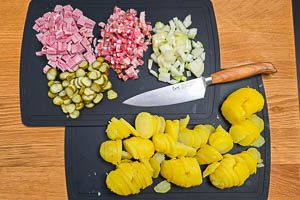 Gepellte Kartoffeln sch&auml;len und weitere Zutaten f&uuml;r das Bauernfr&uuml;hst&uuml;ck schneiden