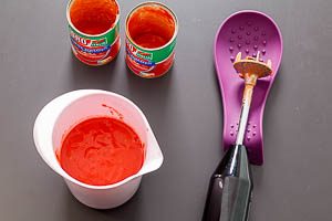 Tomaten aus der Dose passieren.