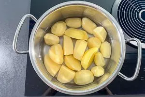 Kartoffeln, wenn n&ouml;tig, halbieren oder vierteln und in einen Topf mit kaltem Wasser geben.