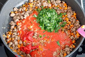 Passierte Tomaten, Tomatenmark und Petersilie hinzugeben, nochmal abschmecken.