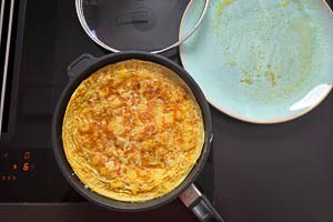 Tortilla mit einem Teller in der Pfanne wenden