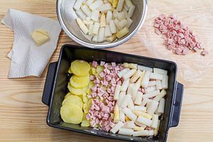 Kartoffel-Spargel-Auflauf in einer Auflaufform schichten