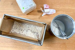 Milch erwärmen, Hefe darin auflösen und die Kastenform für den Brotteig vorbereiten