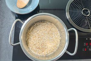 Haferflocken in einem kleinen Topf quellen lassen