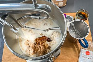 Brühstück, Milch mit Hefe, Salz, Sirup und Brotgewürz in einer Rührschüssel vermengen