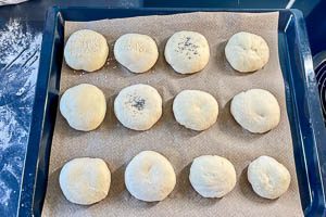 Br&ouml;tchen auf ein Backblech geben und mit K&ouml;rnern bestreuen.