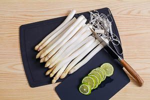 Den Spargel sch&auml;len und vorbereiten und die Limetten in Scheiben schneiden.