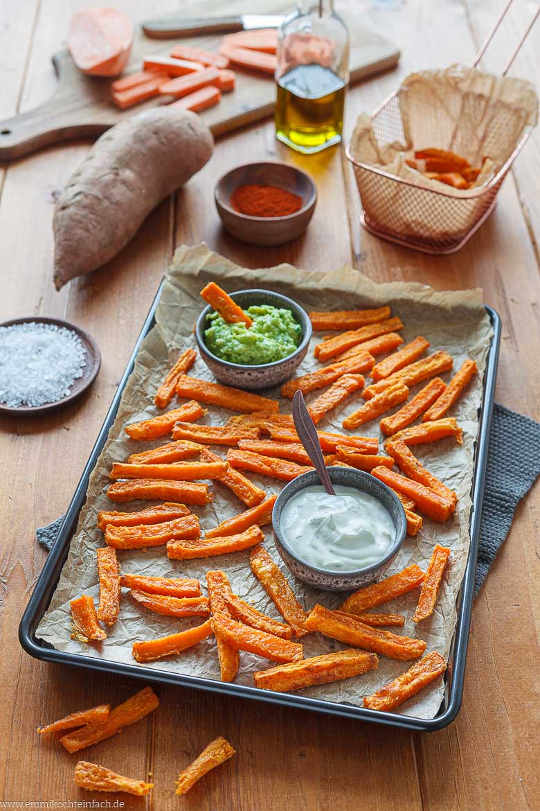Pommes frites aus Süßkartoffeln auf einem Blech mit Dips serviert
