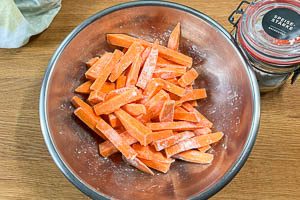 Geschnittene Süßkartoffeln mit Speisestärke bestreuen