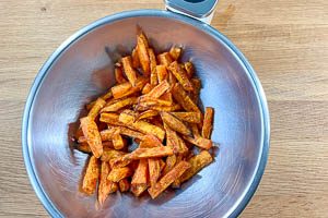 Fertige Pommes aus dem Ofen in eine Schüssel geben und nachwürzen