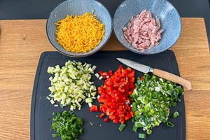 Gemüse, Cheddar und Schinken klein schnippeln.