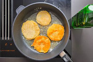 Panierte Kohlrabischeiben beidseitig in der Pfanne anbraten