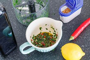 Oliven&ouml;l, Zitronensaft, Chiliflocken, fein gew&uuml;rfelte Knoblauchzehen, gew&uuml;rfelte Chilischote und Petersilie zu einer So&szlig;e vermengen.