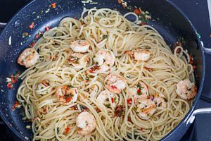Abgetropfte Spaghetti mit Garnelen und der So&szlig;e vermengen.
