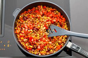 Gib die Tomatenw&uuml;rfel dazu und schmeck die F&uuml;llung ab.