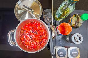 Gemüsezutaten, Essig, Sirup und Gewürze in einem Topf köcheln lassen