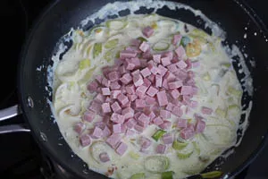 Schinkenw&uuml;rfel in die So&szlig;e geben.