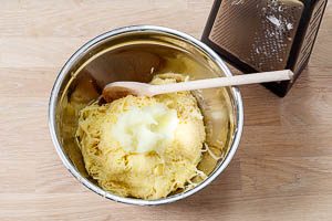 Zwiebeln sch&auml;len und in die Sch&uuml;ssel mit den Kartoffeln reiben