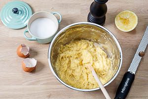 Eier, Gew&uuml;rze und Zitronensaft mit der Kartoffelmasse vermengen