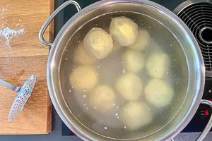 Die Kn&ouml;del im Wasser ziehen lassen.