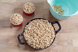 Streusel auf die Apfelspalten geben