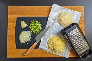 Zwiebeln, Knoblauch und Sellerie waschen und kleinschneiden sowie K&auml;se reiben