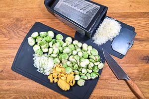 Zwiebeln, Rosenkohl, Kartoffeln und Parmesan f&uuml;r die Suppe vorbereiten