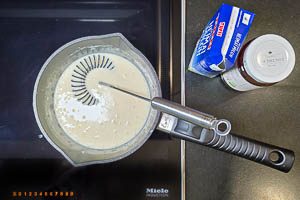 Br&uuml;he und Milch unter schnellem R&uuml;hren dazugeben und aufkochen lassen