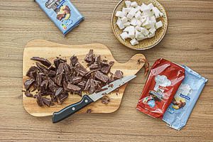 Zartbitter- und Vollmilch-Kuvert&uuml;re zerkleinern, Kokosfett in W&uuml;rfel schneiden