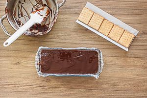 Kekse und Schokolade schichten, bis die Schokocreme verarbeitet ist und mit Schokolade abschlie&szlig;en