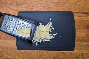 Bergk&auml;se auf einer K&uuml;chenreibe grob reiben