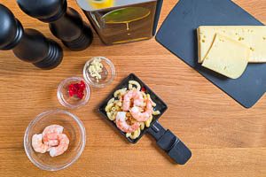 Nudeln vorbereiten und mit K&auml;se und Garnelen toppen.